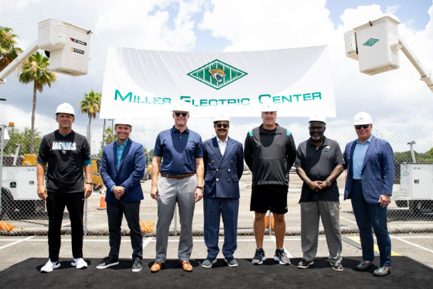 Miller Electric leadership with leadership from Jacksonville Jaguars standing under a banner