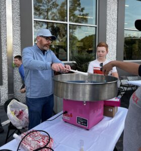 A group of people making cotton candy.