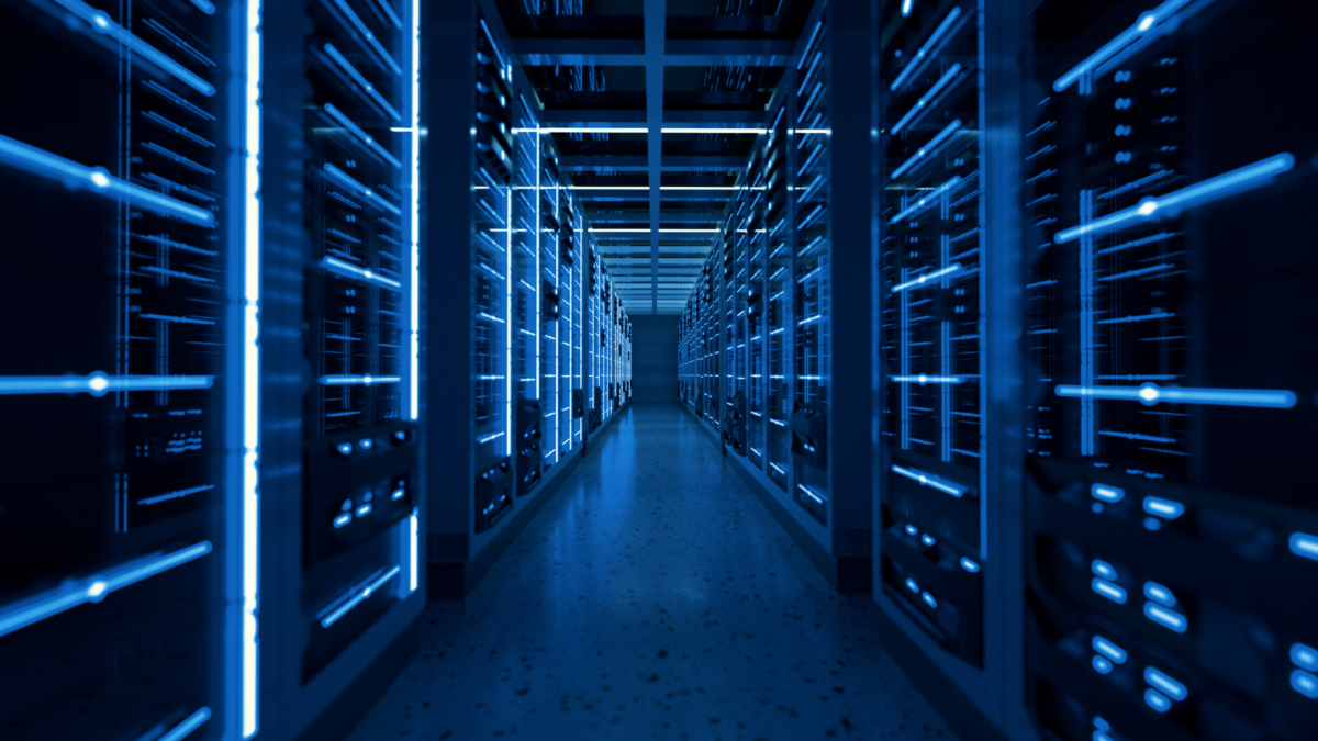 Hallway in a server room between racks of servers.