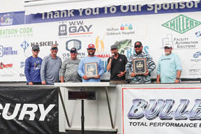 Men on stage hold awards