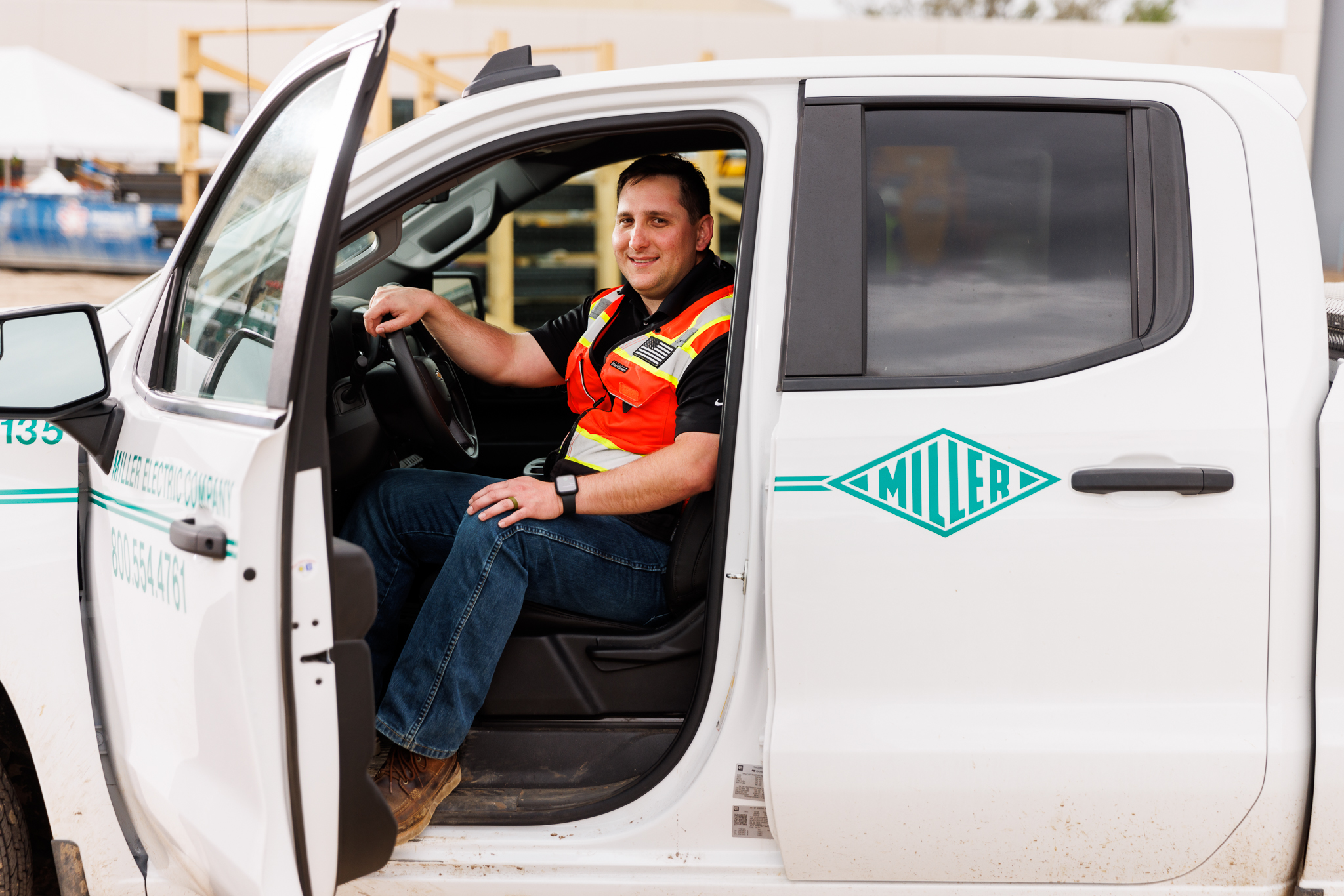 Worker sits in truck with open door and leg approaching exit
