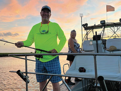 Brian holds a fishing rod on a boat