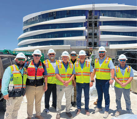 Construction workers stand for photo in hi-vis vests and hard hats