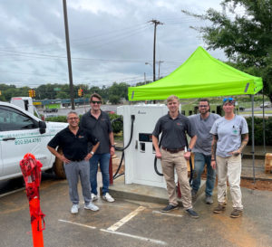 Team standing next to a new EV charger