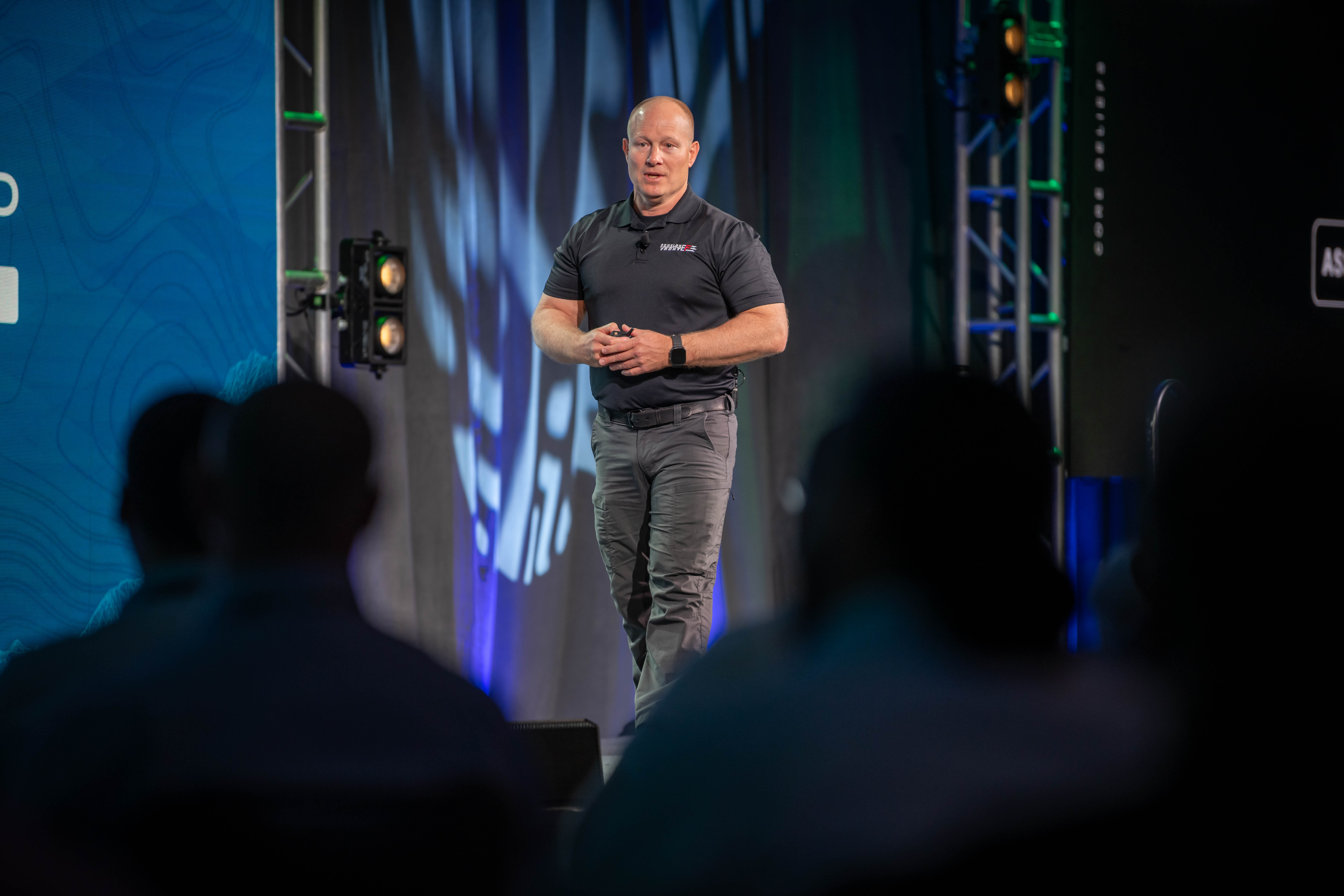 Presenter walks across lit stage while speaking