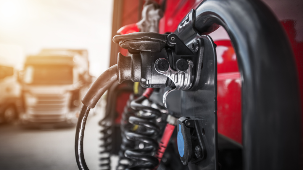 An electric semi truck charging at a charger