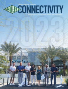 Newsletter cover showing a group of people standing in front of a building and palm trees