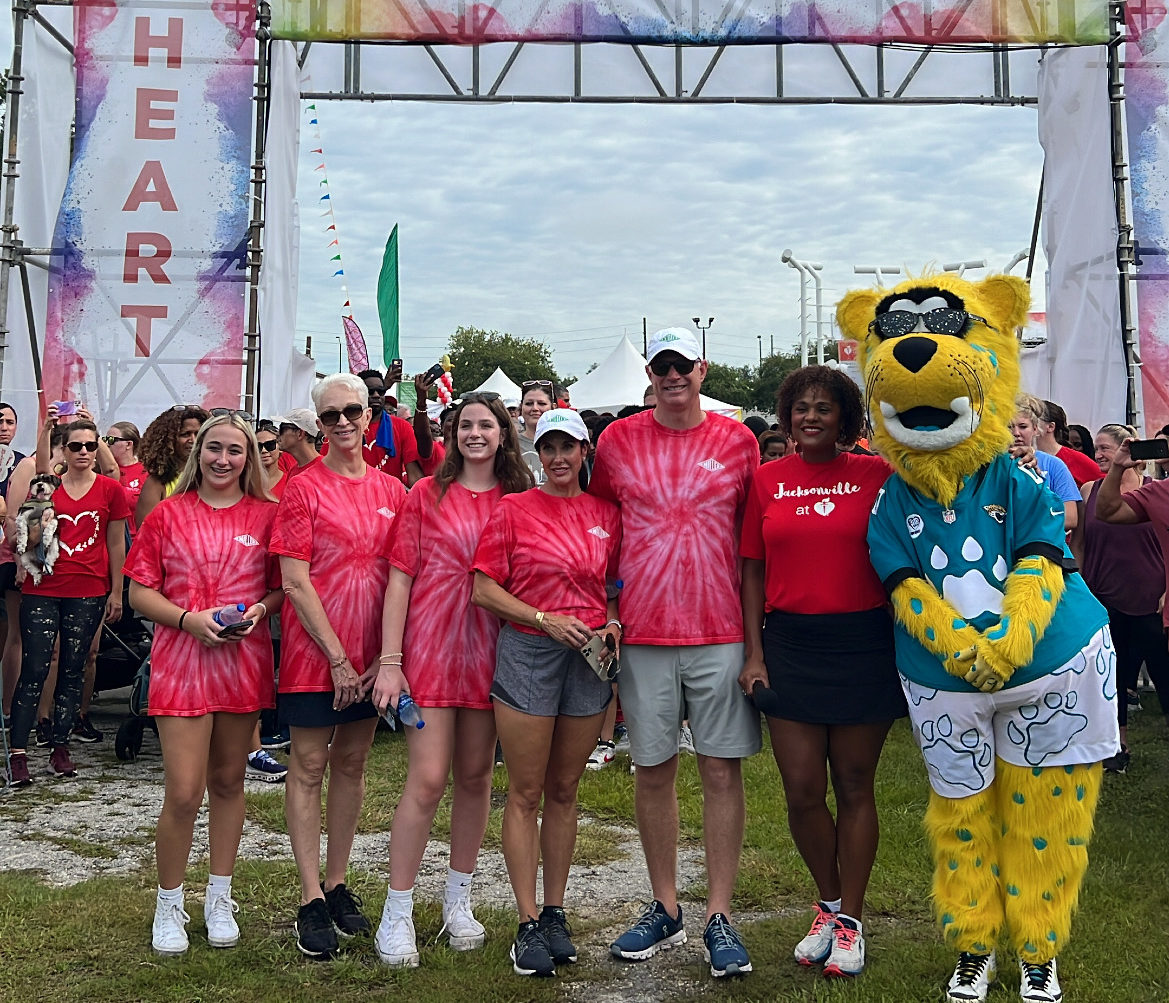 Miller Electric people standing with Jacksonville Jaguars mascot